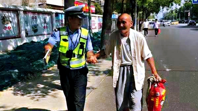 扶老人過馬路 執勤民警平凡舉動暖人心